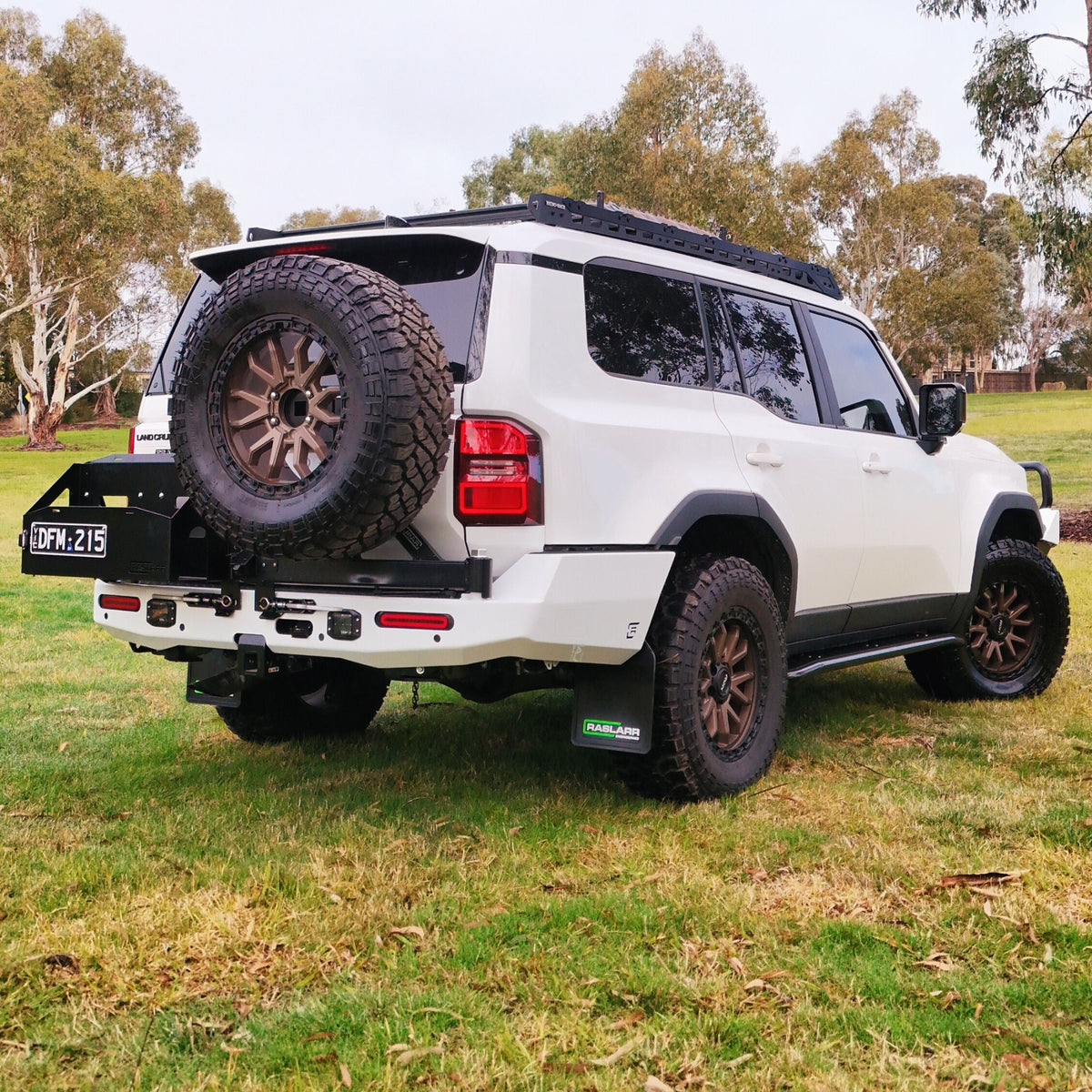 This is an image of the 250 Series Prado Toyota Landcruiser Rear Bar and Wheel Carrier setup by Raslarr Engineering Made in Australia White Black angle