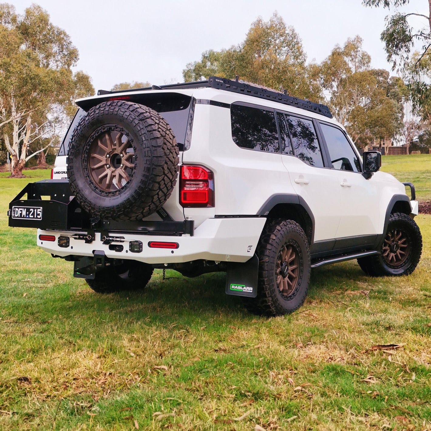 This is an image of the 250 Series Prado Toyota Landcruiser Rear Bar and Wheel Carrier setup by Raslarr Engineering Made in Australia White Black angle